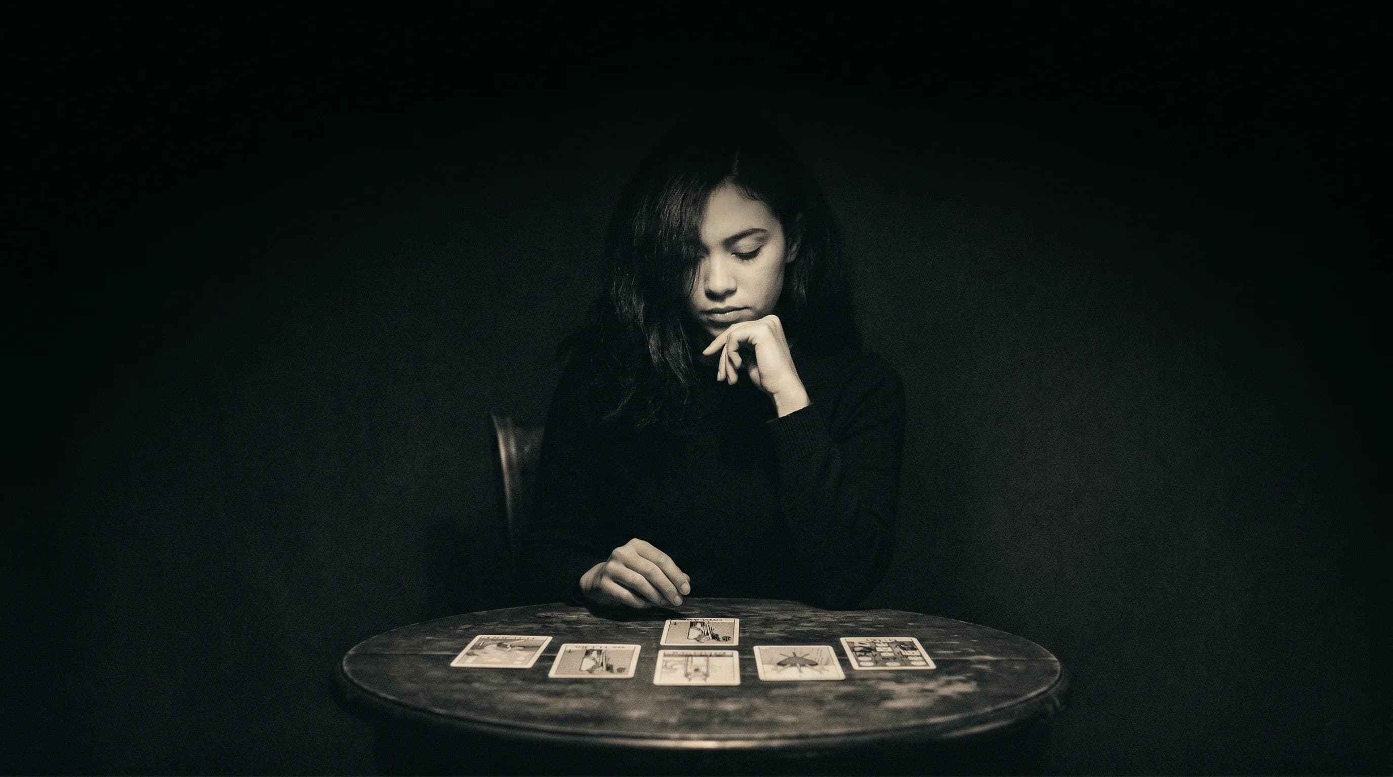 A woman reading tarot cards in warm studio light